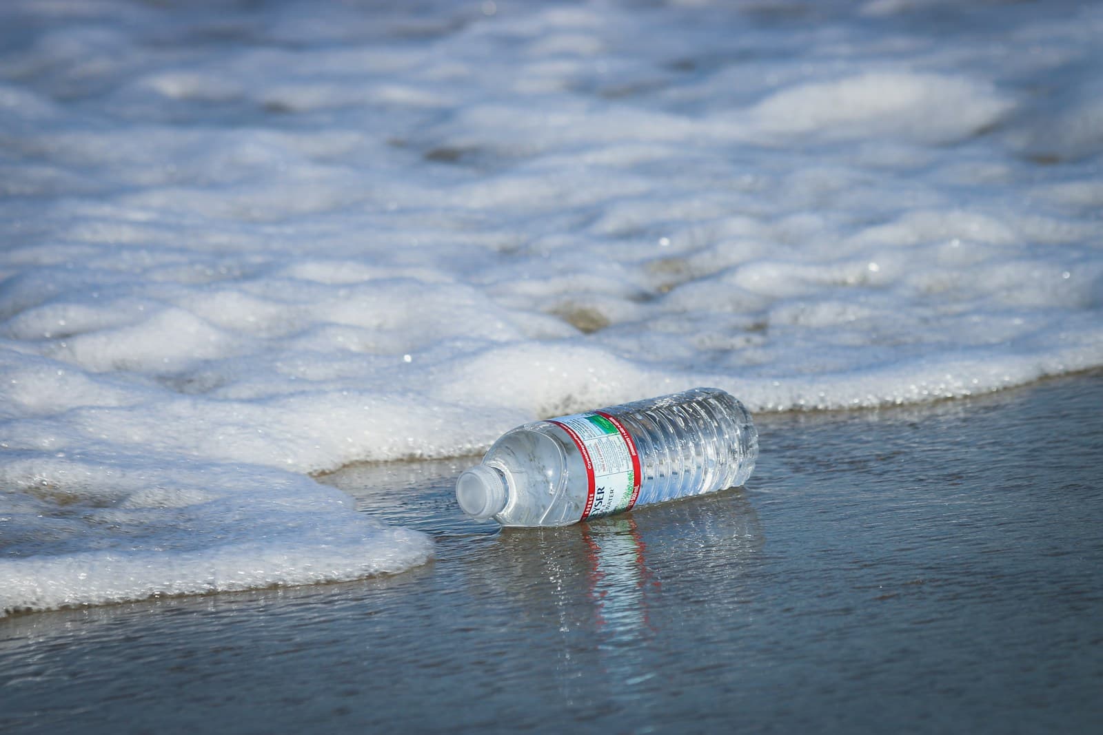 Bottiglia di plastica abbandonata vicino all'acqua